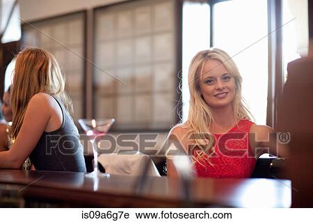 Young woman at bar View Large Photo Image Stock Image - Young woman at bar. Fotosearch