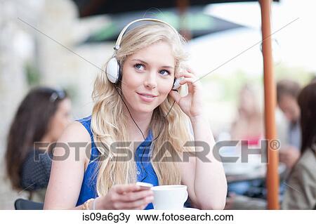 Young woman at cafe wearing head phones View Large Photo Image Stock Photo - Young woman at cafe wearing head phones. Fotosearch