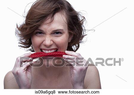 Stock Photo - Young woman biting candy. Fotosearch
