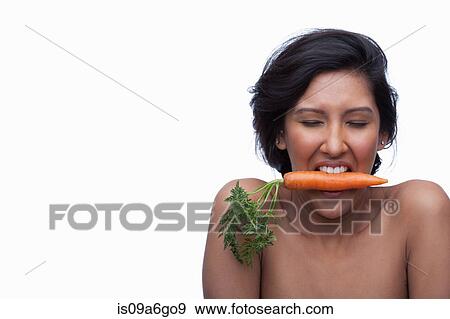 Stock Photo - Young woman biting carrot. Fotosearch