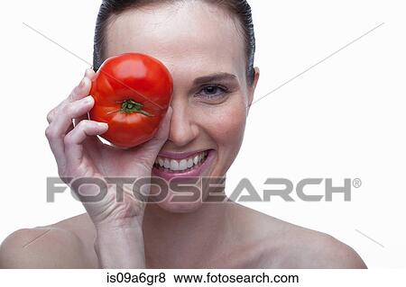 Young woman covering eye with red tomato View Large Photo Image Stock Photo - Young woman covering eye with red tomato. Fotosearch