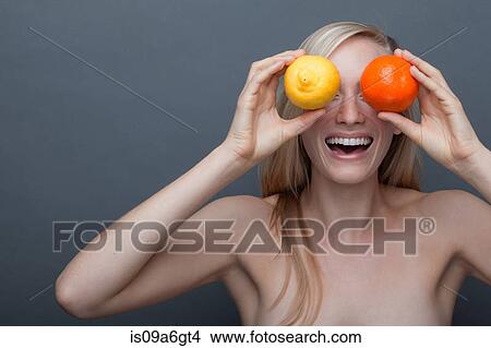 Young woman covering eyes with orange and lemon View Large Photo Image Picture - Young woman covering eyes with orange and lemon. Fotosearch
