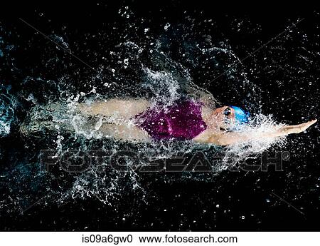 Stock Image - Young woman doing backstroke in swimming pool. Fotosearch