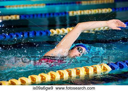 Stock Photo - Young woman doing front crawl in swimming pool. Fotosearch