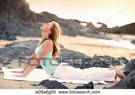 Young woman doing yoga on beach View Large Photo Image Stock Image - Young woman doing yoga on beach. Fotosearch
