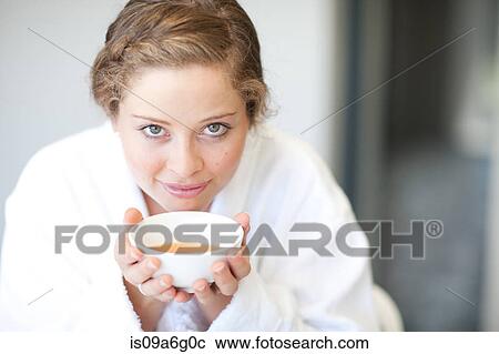 Stock Image - Young woman drinking tea. Fotosearch