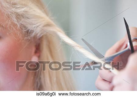 Stock Image - Young woman having haircut, close up. Fotosearch
