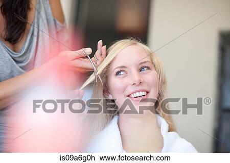 Stock Image - Young woman having haircut. Fotosearch