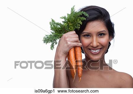 Stock Image - Young woman holding bunch of carrots. Fotosearch