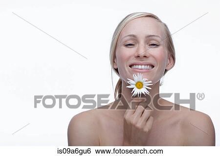 Stock Photograph - Young woman holding daisy. Fotosearch
