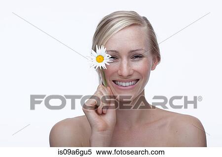 Stock Photography - Young woman holding daisy. Fotosearch