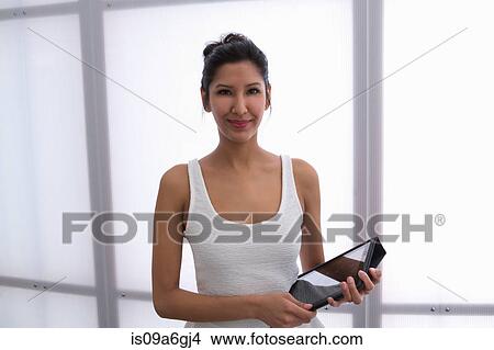 Picture - Young woman holding digital tablet. Fotosearch