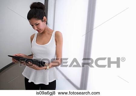 Young woman holding digital tablet, high angle View Large Photo Image Stock Photo - Young woman holding digital tablet, high angle. Fotosearch