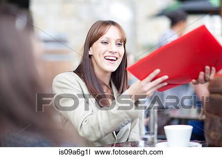 Young woman holding menu in cafe View Large Photo Image Stock Image - Young woman holding menu in cafe. Fotosearch