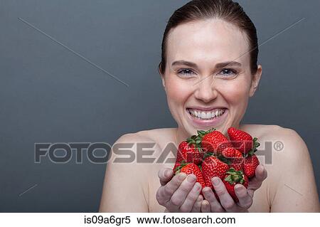 Stock Photography - Young woman holding strawberries. Fotosearch