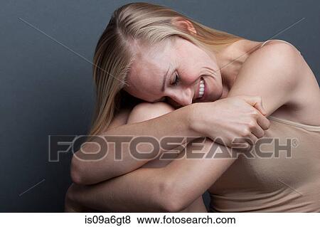 Young woman hugging herself View Large Photo Image Stock Photo - Young woman hugging herself. Fotosearch
