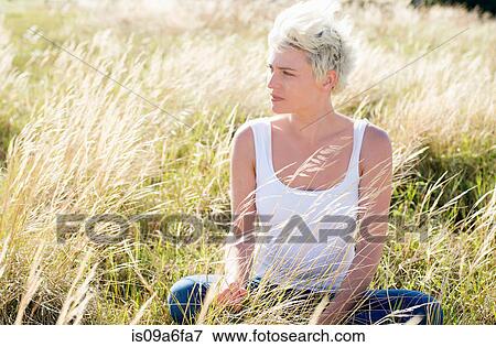 Stock Photo - Young woman in grassy field. Fotosearch