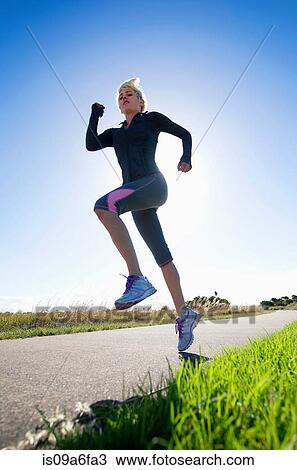 Young woman jogging, low angle View Large Photo Image Stock Image - Young woman jogging, low angle. Fotosearch