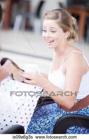 Stock Photograph - Young woman looking at a new shoe. Fotosearch