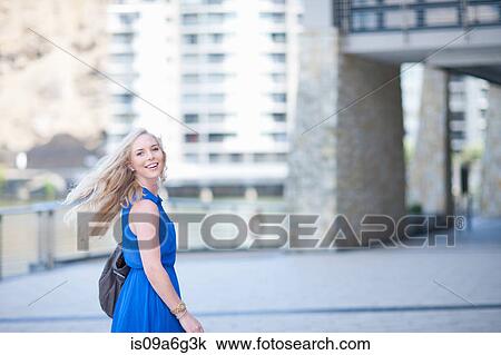 Stock Image - Young woman looking over shoulder at camera. Fotosearch