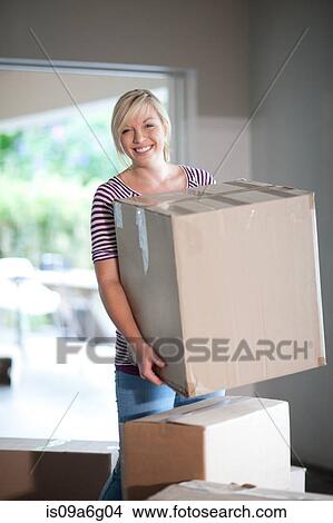 Young woman moving house carrying box View Large Photo Image Picture - Young woman moving house carrying box. Fotosearch
