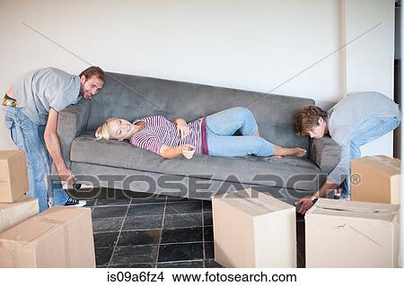 Young Woman Moving House On Sofa Being Carried By Men Picture
