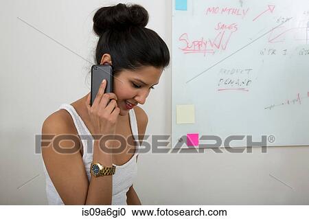 Stock Image - Young woman on smartphone. Fotosearch