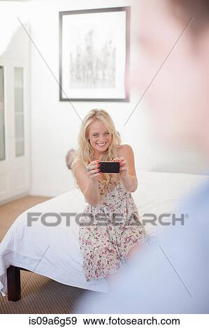 Young woman photographing man with smartphone View Large Photo Image Stock Photo - Young woman photographing man with smartphone. Fotosearch