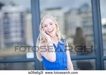 Stock Image - Young woman talking on mobile phone. Fotosearch