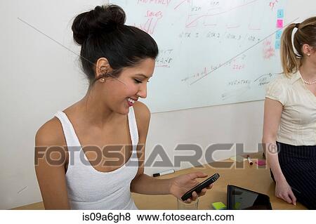 Stock Photo - Young woman texting on smartphone. Fotosearch