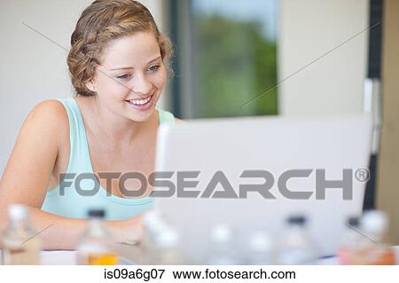 Stock Photo - Young woman using laptop. Fotosearch