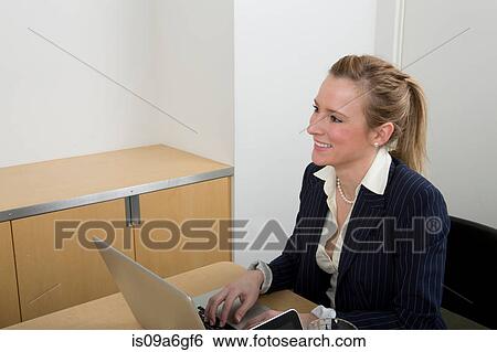 Stock Photograph - Young woman using laptop. Fotosearch