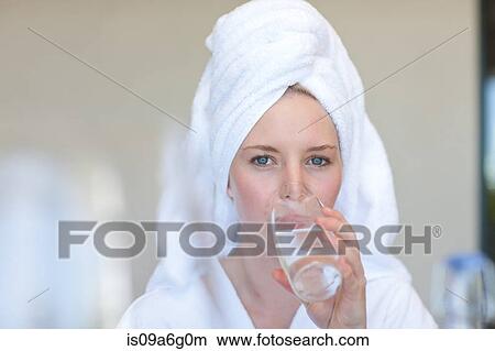 Young woman wearing towel on head drinking water View Large Photo Image Picture - Young woman wearing towel on head drinking water. Fotosearch