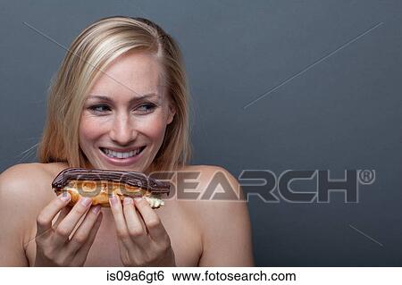 Stock Photograph - Young woman with chocolate eclair. Fotosearch