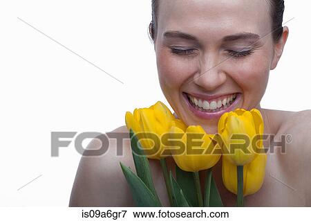 Stock Photo - Young woman with flower in hair and hands on face. Fotosearch