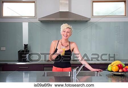 Stock Photo - Young woman with glass of orange juice. Fotosearch