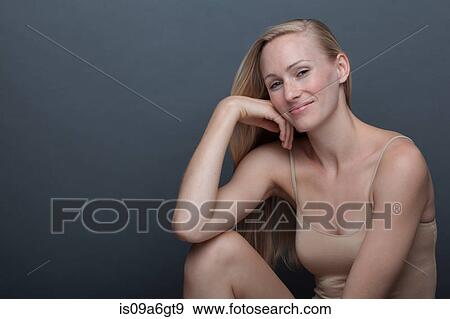 Stock Photo - Young woman with hand on chin. Fotosearch