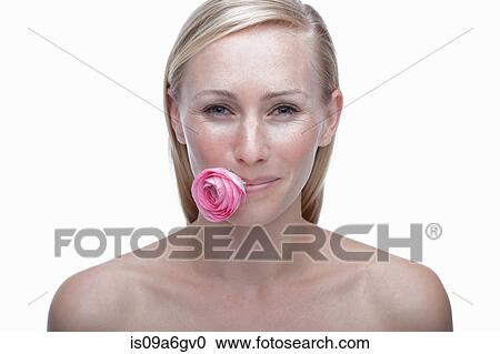 Stock Image - Young woman with pink flower in mouth. Fotosearch