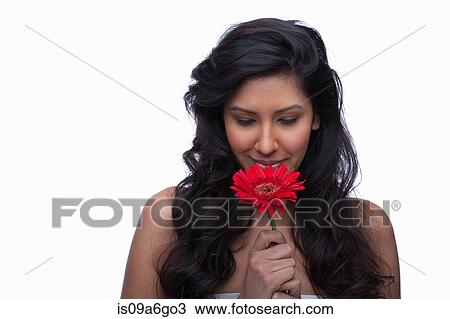 Stock Image - Young woman with red flower. Fotosearch