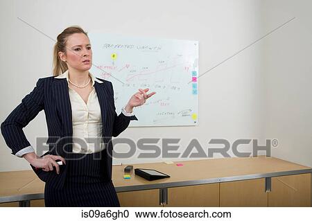 Stock Image - Young woman with whiteboard in background. Fotosearch