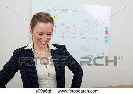 Stock Image - Young woman with whiteboard in background. Fotosearch