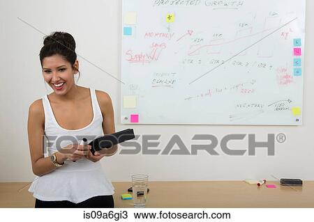 Stock Image - Young woman with whiteboard in background. Fotosearch