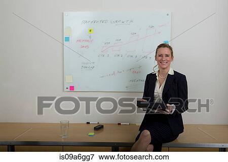 Stock Photo - Young woman with whiteboard in background. Fotosearch