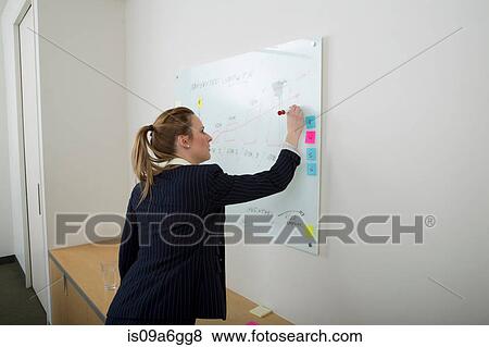 Stock Photo - Young woman writing on whiteboard. Fotosearch