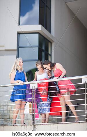 Young women looking into shopping bags View Large Photo Image Stock Image - Young women looking into shopping bags. Fotosearch