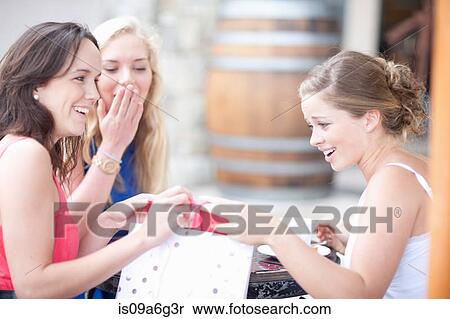 Young women showing each other their shopping View Large Photo Image Stock Photography - Young women showing each other their shopping. Fotosearch