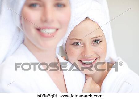Stock Photograph - Young women with towels on heads in spa. Fotosearch