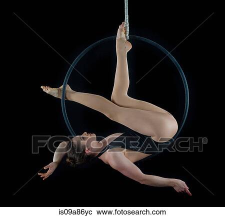 Aerialist performing on hoop in front of black background View Large Photo Image Stock Image - Aerialist performing on hoop in front of black background. Fotosearch