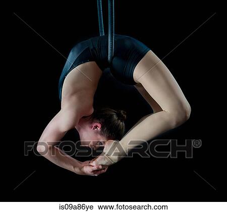 Aerialist performing on hoop in front of black background View Large Photo Image Stock Image - Aerialist performing on hoop in front of black background. Fotosearch