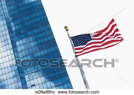 American flag flying by modern skyscraper View Large Photo Image Stock Image - American flag flying by modern skyscraper. Fotosearch